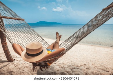 Summer travel vacation concept, Happy traveler asian woman with hat relax in hammock on beach in Koh Rap, Samui, Surat Thani, Thailand - Powered by Shutterstock