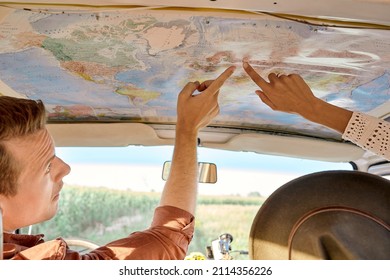 Summer trip concept. cropped friends or couple looking at map to plan a camper van trip pointing finger at map. rear view, view from back. vacation, holidays, adventure, journey, trip, travel - Powered by Shutterstock