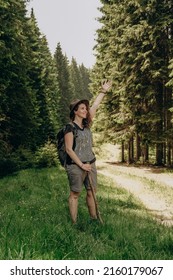 Summer trip to the mountains. A woman walks in the forest in summer. Hiking in the mountains. Active holiday in summer. Walk along the forest road. - Shutterstock ID 2160179067