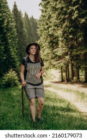 Summer trip to the mountains. A woman walks in the forest in summer. Hiking in the mountains. Active holiday in summer. Walk along the forest road. - Shutterstock ID 2160179073