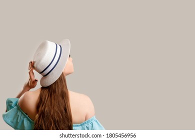 Summer trip. Travel information. Woman in off-the-shoulder blue dress and white gypsy hat looking copy space isolated on neutral backside. Holiday outfit. Vacation tour. Advertising background