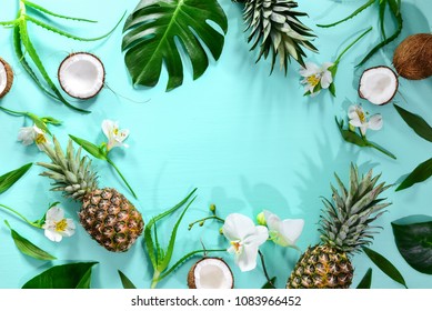 Summer tropical background with a space for a text, various fruits, green leaves and flowers arranged in a way that light shadows are fallen on the background surface, helping to keep some sum - Powered by Shutterstock