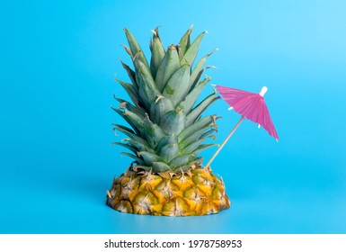 Summer Tropical Pineapple With Cocktail Umbrella On Blue Sea Background. Tropical Vacation, Island, Beach, Vacation, Summer And Travel Creative Minimal Concept