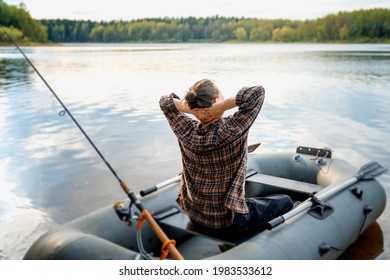 Summer vacation and activity. Young beautiful woman sailing on an inflatable boat with a fishing rod on forest lake - Powered by Shutterstock