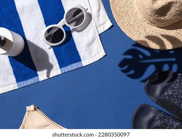 Summer vacation beach concept frame with retro sunglasses, striped towel and straw hat on the blue background. Copy space - Powered by Shutterstock