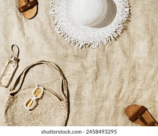 Summer vacation, beach rest concept, aesthetic flat lay fashion beach bag, white sun hat, leather sandals, detox drink lemon water on beach towel at sunlight, lifestyle trendy vintage photo, top view