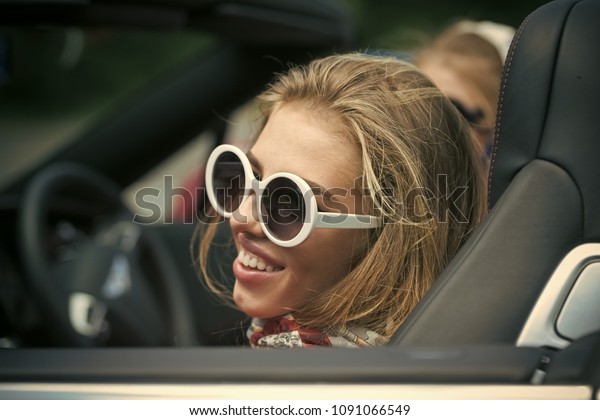 Summer vacation car road trip freedom\
concept. Happy woman cheering joyful during holiday travel in\
vintage car. Beautiful young Caucasian female\
model