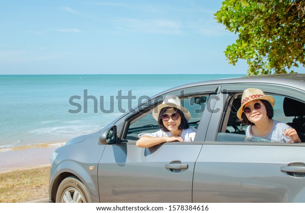 Summer Vacation and Car Trip Concept :\
Family car trip at the sea, Woman and child cheerful in car with\
seascape in the background, They feeling\
happiness.