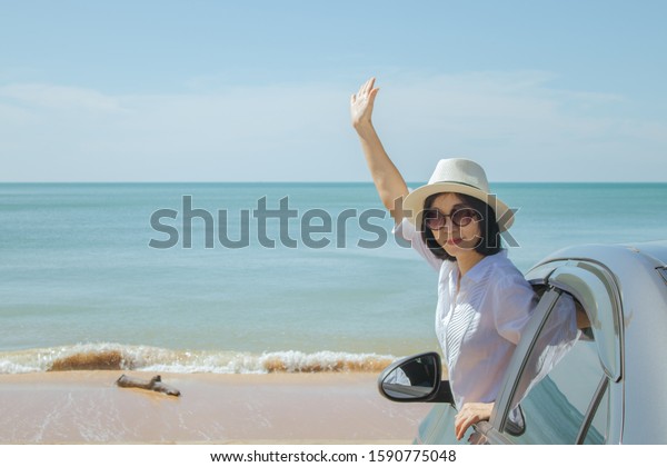 Summer Vacation and Car Trip Concept : Family car\
trip at the sea, Asian woman feeling happiness and she raising hers\
hands up over head.