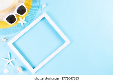 Summer Or Vacation Concept. Beach Hat And  Sunglasses With Photo Frame On Light Blue Background. Copy Space.