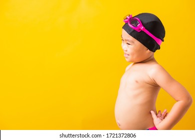 Summer Vacation Concept, Closeup Portrait Asian Happy Cute Little Child Boy Wearing Goggles And Swimsuit, Kid Having Fun With In Summer Vacation Looking Side, Studio Shot Isolated Yellow Background