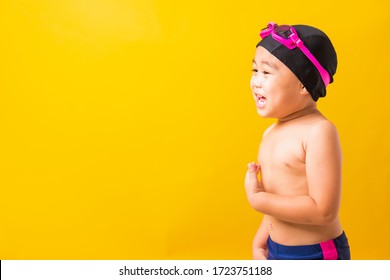 Summer Vacation Concept, Closeup Portrait Asian Happy Cute Little Child Boy Wearing Goggles And Swimsuit, Kid Having Fun With In Summer Vacation Looking Side, Studio Shot Isolated Yellow Background