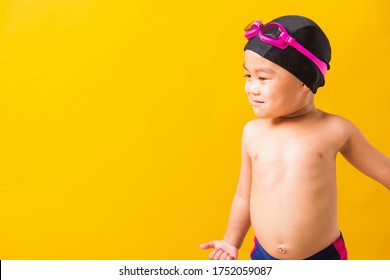 Summer Vacation Concept, Closeup Portrait Asian Happy Cute Little Child Boy Wearing Goggles And Swimsuit, Kid Having Fun With In Summer Vacation Looking Side, Studio Shot Isolated Yellow Background