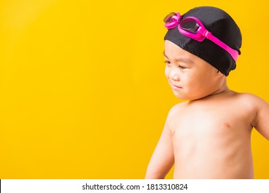 Summer Vacation Concept, Closeup Portrait Asian Happy Cute Little Child Boy Wearing Goggles And Swimsuit, Kid Having Fun With In Summer Vacation Looking Side, Studio Shot Isolated Yellow Background