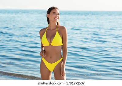 Summer Vacation Concept. Lady In Swimwear Standing On Beach Sunbathing Near Sea Looking Aside. Blank Space For Text