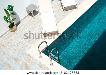 Summer vacation concept, pool lifestyle, top view of poolside with sun loungers and tropical plant