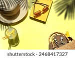Summer vacation flat lay, yellow - straw sun hat sunglasses on book with drink palm shadows