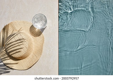 Summer vacation. Hat on the travertine stone by the beautiful swimming pool. Blue sea surface with waves, texture water.