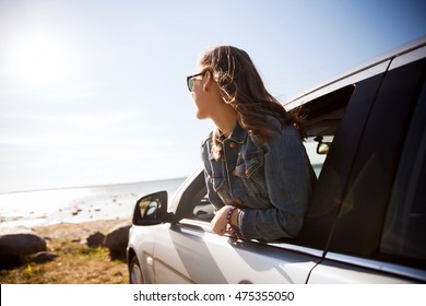 Summer Vacation, Holidays, Travel, Road Trip And People Concept - Happy Smiling Teenage Girl Or Young Woman In Car At Seaside