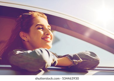 Summer Vacation, Holidays, Travel, Road Trip And People Concept - Happy Smiling Teenage Girl Or Young Woman In Car