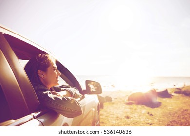 summer vacation, holidays, travel, road trip and people concept - happy smiling teenage girl or young woman in car at seaside - Powered by Shutterstock