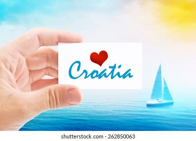 Summer Vacation on Croatia Beach, Person Holding Visiting Card for Summertime Holiday Message Love Croatia and Sailboat at Sea in Background.
