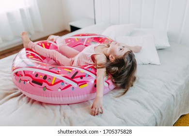 Summer Vacation On Quarantine, A Kid With Donut Tube At Home, Baby Girl With Pink Rubber Ring, Home Self-isolation In Summer