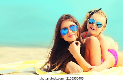 Summer Vacation Portrait Mother And Child Lying Together On Beach, Background Of Sea