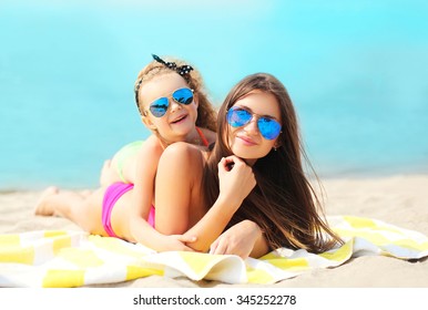 Summer Vacation, Relaxation, Travel - Mother And Child Lying Resting On Beach Together