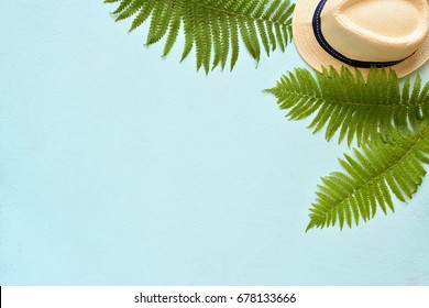 Summer Vacation, Resort Theme. White Bucket Hat With On Blue Background With Green Palm Leaves. Flat Lay