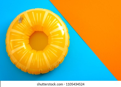 Summer vacation and safety equipment for swimming with a life buoy isolated on an orange and blue minimalist background with copy space - Powered by Shutterstock