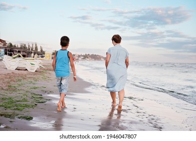 Summer Vacation At Sea. Boy And Senior Woman At Seaside. Grandmother With Grandchild Are Resting On Sea, Running On Beach Having Fun At Summer Holiday. Active Parents, People Activity With Children.