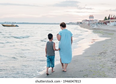 Summer Vacation At Sea. Boy And Senior Woman At Seaside. Grandmother With Grandchild Are Resting On Sea, Running On Beach Having Fun At Summer Holiday. Active Parents, People Activity With Children.