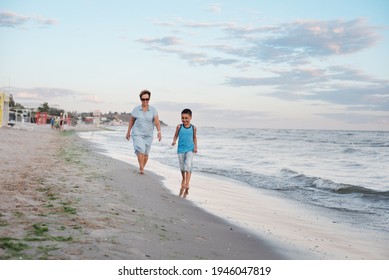 Summer Vacation At Sea. Boy And Senior Woman At Seaside. Grandmother With Grandchild Are Resting On Sea, Running On Beach Having Fun At Summer Holiday. Active Parents, People Activity With Children.