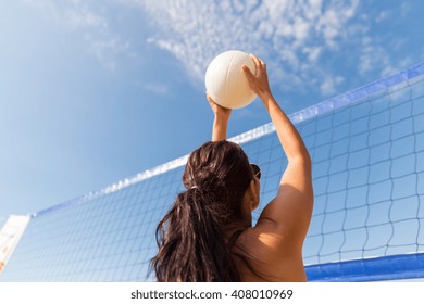summer vacation, sport, leisure and people concept - young woman with ball playing volleyball on beach