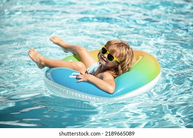 Summer Vacation. Summertime Kids Weekend. Boy In Swiming Pool. Funny Boy On Inflatable Rubber Circle.