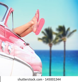 Summer vacation travel freedom concept with cool convertible vintage car and woman feet out of window against tropical sea background with palm trees. Girl relaxing enjoying vacation. - Powered by Shutterstock