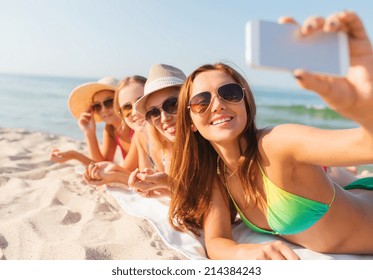 Summer Vacation, Travel, Technology And People Concept - Group Of Smiling Women In Sunglasses Making Selfie With Smartphone On Beach