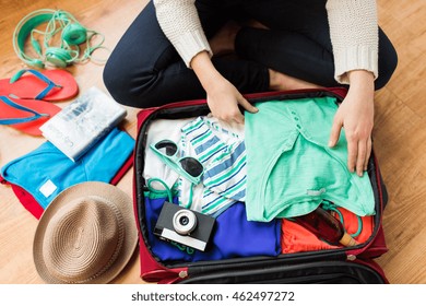 Summer Vacation, Travel, Tourism And Objects Concept - Close Up Of Woman Packing Travel Bag For Vacation