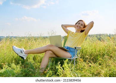 Summer Vacation In Wild Meadow, Adult Woman Resting On Folding Chair For Camping Using Laptop