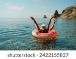 Summer vacation woman in hat floats on an inflatable donut mattress. Happy woman relaxing and enjoying family summer travel holidays travel on the sea.