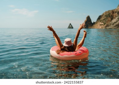 Summer vacation woman in hat floats on an inflatable donut mattress. Happy woman relaxing and enjoying family summer travel holidays travel on the sea. - Powered by Shutterstock