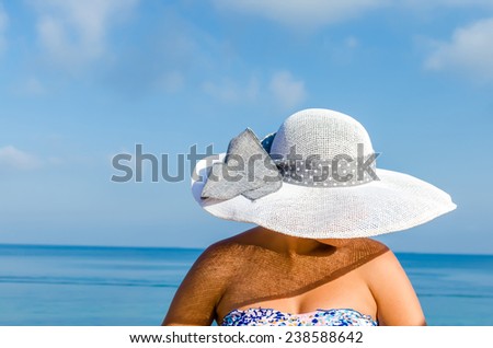 Summer vacation woman with straw hat enjoying summer holidays looking at the ocean