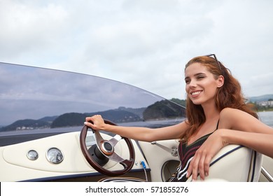Summer vacation - young girl driving a motor boat 