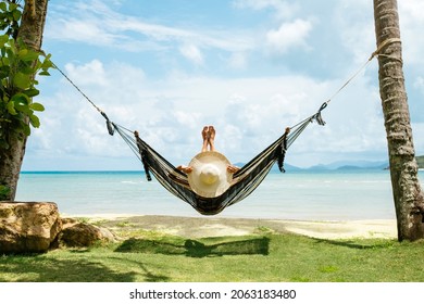 Summer vacations concept. Happy woman in black bikini relaxing in hammock on tropical beach - Shutterstock ID 2063183480