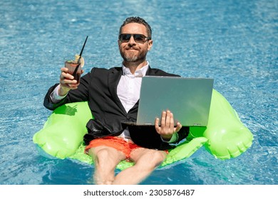 Summer vacations and freedom travel concept. Portrait of funny business man on the beach. Businessman in suit floating with laptop and cocktail in pool. Crazy business man dreams on summer vacation. - Powered by Shutterstock