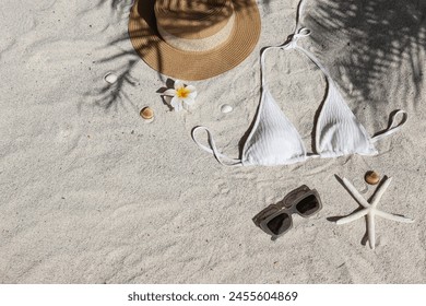 Summer vibes. Straw hat, bathing suit and sunglasses on a sandy beach.. Flat lay, copy space, top view, background. - Powered by Shutterstock