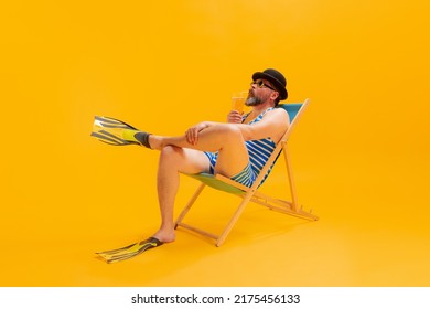 Summer Vibes. Studio Shoot Of Cool Funny Beachgoer, Man In Vintage Striped Swimsuit And Bowler Hat Sitting In Sunbed Isolated On Yellow Background. Leisure Activity, Vacation, Summer, Sales