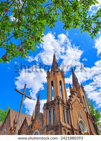 Summer view on Transfiguration Church and Organ hall against blue sky. Catholic church in Krasnoyarsk in Russia was built in neo-Gothic style in 1908-1911.