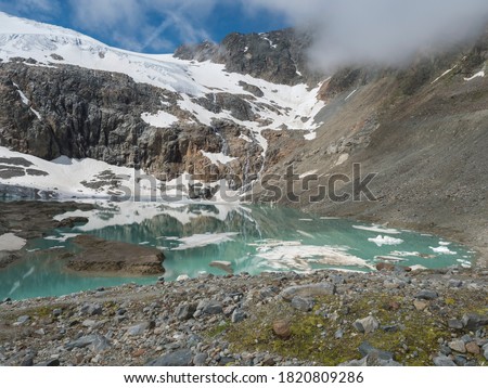 summer view of the Sulzenauferner Glacier and turquoise glacial lake and waterfall from melting ice. Stubai Alps, Austria